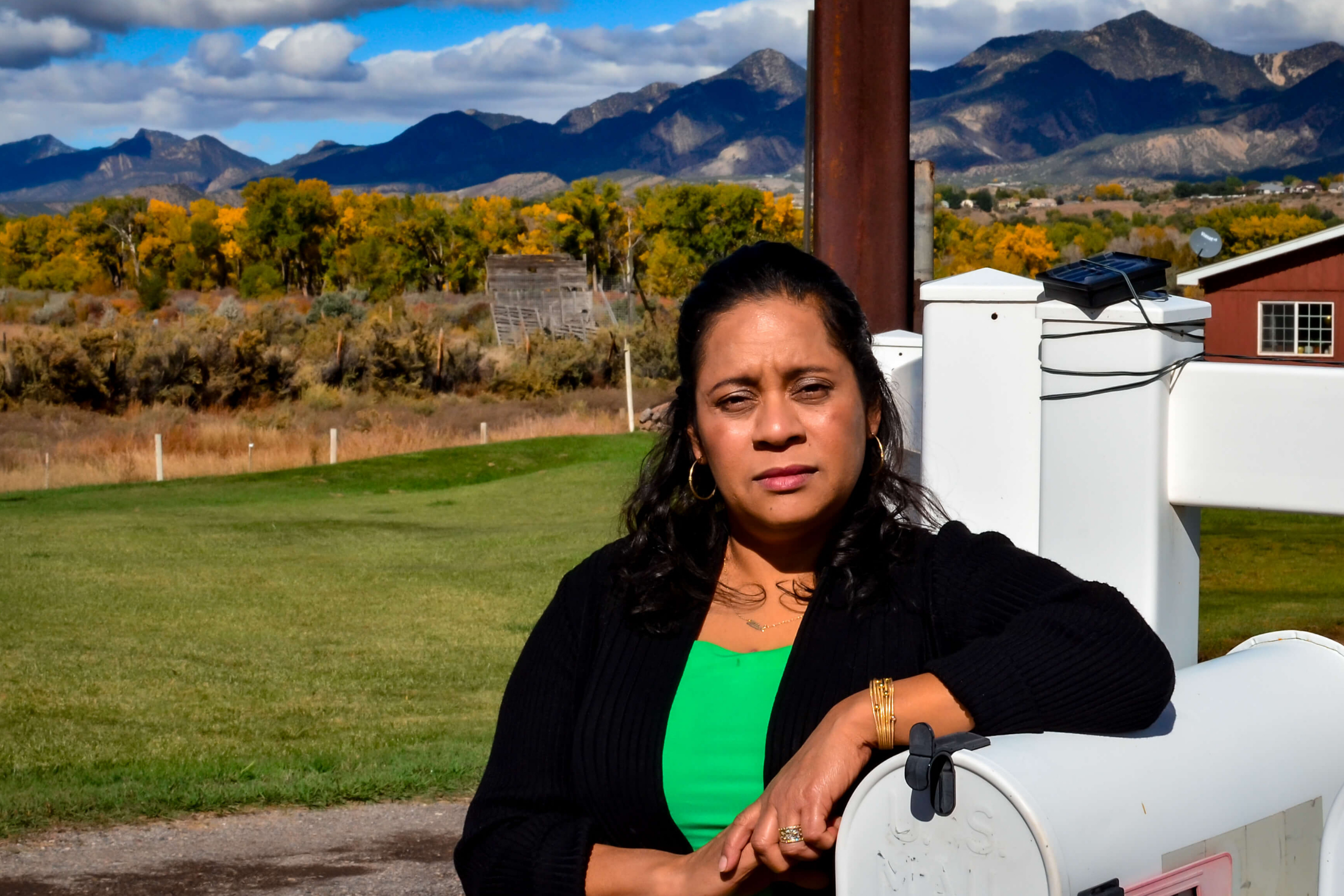 The Savings Collaborative's Alma Guzman stands in front of her home in rural Colorado